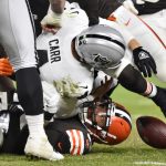 
              Las Vegas Raiders quarterback Derek Carr, top, is sacked by Cleveland Browns defensive end Myles Garrett, bottom, during the second half of an NFL football game, Monday, Dec. 20, 2021, in Cleveland. (AP Photo/David Richard)
            