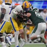 
              Pittsburgh quarterback Davis Beville (17) is sacked by Michigan State defensive end Jacub Panasiuk (96) during the second half of the Peach Bowl NCAA college football game, Thursday, Dec. 30, 2021, in Atlanta. (AP Photo/John Bazemore)
            