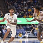 
              West Virginia forward Isaiah Cottrell (13) drives to the basket while being guarded by Kent State forward Justyn Hamilton (21) during the first half of an NCAA college basketball game in Morgantown, W.Va., Sunday, Dec. 12, 2021. (AP Photo/William Wotring)
            