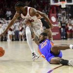 
              Florida guard Brandon McKissic (23) slips as he tries to get the ball away from Oklahoma guard Elijah Harkless (55) during the first half of an NCAA college basketball game in Norman, Okla., Wednesday, Dec. 1, 2021. (AP Photo/Kyle Phillips)
            