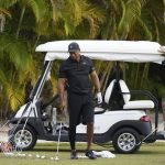 
              Tiger Woods, left, sets a ball during a practice session at the Albany Golf Club, in New Providence, Bahamas, Saturday, Dec. 4, 2021. Fitness instructor Kolby Wayne is pictured right. (AP Photo/Fernando Llano)
            