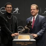 
              Alabama quarterback Bryce Young, left, stands alongside head coach Nick Saban for a photograph after winning the Heisman Trophy, Saturday, Dec. 11, 2021, in New York. (AP Photo/John Minchillo)
            