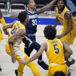 
              Monmouth guard Shavar Reynolds (33) goes up to shoot between Pittsburgh guard William Jeffress (24) and John Hugley (23) during the first half of an NCAA college basketball game in Pittsburgh, Sunday, Dec. 12, 2021. (AP Photo/Gene J. Puskar)
            
