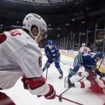 
              Carolina Hurricanes' Martin Necas (88), of the Czech Republic, and Jesperi Kotkaniemi (82), of Finland, vie for the puck against Vancouver Canucks' Kyle Burroughs (44) and Elias Pettersson (40), of Sweden, during the first period of an NHL hockey game in Vancouver, British Columbia, Sunday, Dec. 12, 2021. (Darryl Dyck/The Canadian Press via AP)
            