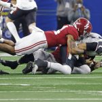 
              Cincinnati quarterback Desmond Ridder (9), right, is sacked by Alabama's Brian Branch (14) and Will Anderson Jr. during the second half of the Cotton Bowl NCAA College Football Playoff semifinal game, Friday, Dec. 31, 2021, in Arlington, Texas. (AP Photo/Michael Ainsworth)
            