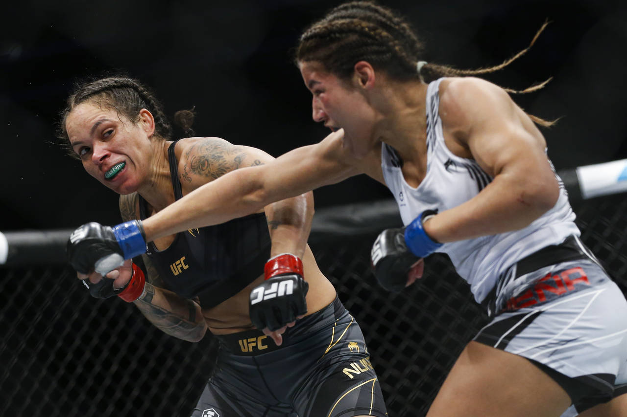 Julianna Pena, right, throws a right to Amanda Nunes during a women's bantamweight mixed martial ar...