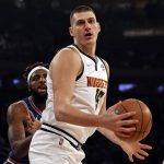 
              Denver Nuggets center Nikola Jokic (15) drives past New York Knicks center Mitchell Robinson during the first half of an NBA basketball game Saturday, Dec. 4, 2021, in New York. (AP Photo/Adam Hunger)
            