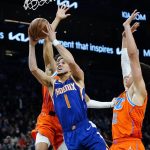
              Phoenix Suns guard Devin Booker (1) drives past Oklahoma City Thunder forward Isaiah Roby (22) and guard Aaron Wiggins, left, during the second half of an NBA basketball game Wednesday, Dec. 29, 2021, in Phoenix. The Suns won 115-97. (AP Photo/Ross D. Franklin)
            