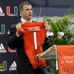 
              Miami new football coach, Mario Cristobal, holds up a jersey after being introduced at a news conference Tuesday, Dec. 7, 2021, in Coral Gables, Fla. Cristobal is returning to his alma mater, where he won two championships as a player. (AP Photo/Lynne Sladky)
            