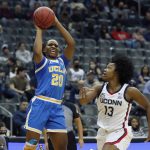 
              UCLA guard Charisma Osborne (20) shoots over Connecticut guard Christyn Williams (13) during the first half of an NCAA college basketball game in Newark, N.J., Saturday, Dec. 11, 2021. (AP Photo/Noah K. Murray)
            