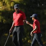 
              Tiger Woods fist bumps his son Charlie Woods on the 16th green during the second round of the PNC Championship golf tournament, Sunday, Dec. 19, 2021, in Orlando, Fla. (AP Photo/Scott Audette)
            