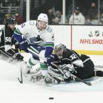
              Vancouver Canucks' Quinn Hughes, center, goes after the puck deflected by Los Angeles Kings goaltender Jonathan Quick during first period of an NHL hockey game Thursday, Dec. 30, 2021, in Los Angeles. (AP Photo/Jae C. Hong)
            