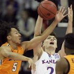 
              Kansas' Christian Braun, center, shoots under pressure from UTEP's Emmanuel White (5) and Keonte Kennedy (3) during the first half of an NCAA college basketball game Tuesday, Dec. 7, 2021, in Kansas City, Mo. (AP Photo/Charlie Riedel)
            