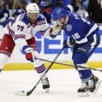 
              New York Rangers defenseman K'Andre Miller (79) knocks the puck away from Tampa Bay Lightning left wing Ondrej Palat (18) during the second period of an NHL hockey game Friday, Dec. 31, 2021, in Tampa, Fla. (AP Photo/Chris O'Meara)
            