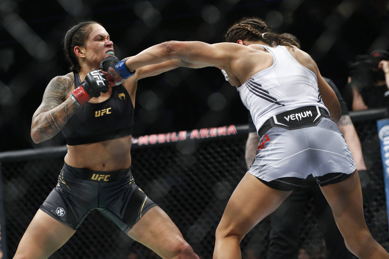 Amanda Nunes, left, fights Julianna Pena during a women's bantamweight mixed martial arts title bou...