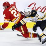 
              Boston Bruins' Patrice Bergeron, right, loses his stick and takes down Calgary Flames' Sean Monahan dduring the first period of an NHL hockey game Saturday, Dec. 11, 2021, in Calgary, Alberta. (Larry MacDougal/The Canadian Press via AP)
            