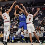 
              Minnesota Timberwolves center Karl-Anthony Towns (32) is boxed in by Cleveland Cavaliers center Jarrett Allen (31) and forward Evan Mobley during the first half of an NBA basketball game Friday, Dec. 10, 2021, in Minneapolis. (AP Photo/Craig Lassig)
            