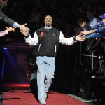 
              FILE - Former New York Knicks star Walt Frazier is greeted by fans as he comes onto the court during halftime of the Knicks' NBA basketball game against the Milwaukee Bucks, Feb. 22, 2010, at Madison Square Garden in New York. (AP Photo/Bill Kostroun, File)
            
