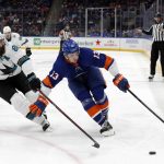 
              New York Islanders center Mathew Barzal (13) tries to skate with the puck past San Jose Sharks defenseman Brent Burns (88) during the second period of an NHL hockey game on Thursday, Dec. 2, 2021, in Elmont, N.Y. (AP Photo/Jim McIsaac)
            