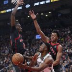 
              Milwaukee Bucks' Thanasis Antetokounmpo, lower right, looks to pass the ball away from Toronto Raptors' Chris Boucher, left, and Scottie Barnes during the first half of an NBA basketball game Thursday, Dec. 2, 2021, in Toronto. (Chris Young/The Canadian Press via AP)
            