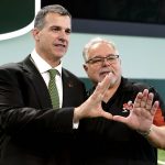
              Mario Cristobal, left, Miami's new football coach, makes the sign of the "U" with Harry Rothwell, right, after being introduced at a NCAA college football news conference, Tuesday, Dec. 7, 2021, in Coral Gables, Fla. Cristobal is returning to his alma mater, where he won two championships as a player. Rothwell is a local businessman and Hurricanes fan. (AP Photo/Lynne Sladky)
            