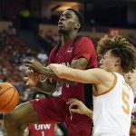 
              Incarnate Word guard Bradley Akhile (0) is fouled by Texas guard Devin Askew (5) during the first half of an NCAA college basketball game, Tuesday, Dec. 28, 2021, in Austin, Texas. (AP Photo/Eric Gay)
            