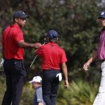 
              Tiger Woods fist bumps his son Charlie Woods on the the third green during the second round of the PNC Championship golf tournament Sunday, Dec. 19, 2021, in Orlando, Fla. (AP Photo/Scott Audette)
            