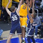 
              Pittsburgh forward John Hugley (23) gets off a pass between Monmouth forward Klemen Vuga (35) and Shavar Reynolds during the first half of an NCAA college basketball game in Pittsburgh, Sunday, Dec. 12, 2021. (AP Photo/Gene J. Puskar)
            