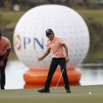 
              Charlie Woods reacts to missing a putt on 16th green as father Tiger Woods watches during the first round of the PNC Championship golf tournament Saturday, Dec. 18, 2021, in Orlando, Fla. (AP Photo/Scott Audette)
            