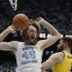 
              North Carolina forward Brady Manek (45) reacts following a dunk against Michigan center Hunter Dickinson (1) during the first half of an NCAA college basketball game in Chapel Hill, N.C., Wednesday, Dec. 1, 2021. (AP Photo/Gerry Broome)
            