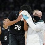 
              Michigan State forward Malik Hall (25) is helped off the court during the first half of an NCAA college basketball game against Oakland , Tuesday, Dec. 21, 2021, in Detroit. (AP Photo/Carlos Osorio)
            