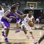 
              Baylor guard Adam Flagler drives on Northwestern State center Larry Owens, left, during the second half of an NCAA college basketball game Tuesday, Dec. 28, 2021, in Waco, Texas. (AP Photo/Rod Aydelotte)
            