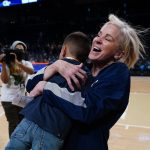 
              Georgia Tech coach Nell Fortner celebrates with nine-year-old Breden Garcia after Georgia Tech defeated Connecticut in an NCAA college basketball game Thursday, Dec. 9, 2021, in Atlanta. (AP Photo/John Bazemore)
            