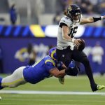 
              Jacksonville Jaguars quarterback Trevor Lawrence, right, is tackled by Los Angeles Rams defensive end Greg Gaines during the first half of an NFL football game Sunday, Dec. 5, 2021, in Inglewood, Calif. (AP Photo/Jae C. Hong)
            