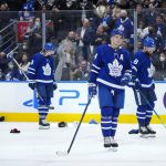 
              Toronto Maple Leafs forward Auston Matthews, foreground, skates slowly as fans throw hats onto the ice in celebration of his hat trick against the Colorado Avalanche, during the third period of an NHL hockey game Wednesday, Dec 1, 2021, in Toronto. (Nathan Denette/The Canadian Press via AP)
            