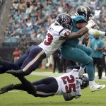 
              Jacksonville Jaguars running back James Robinson, right, is tackled by Houston Texans middle linebacker Neville Hewitt, left, and cornerback Desmond King (25) during the first half of an NFL football game, Sunday, Dec. 19, 2021, in Jacksonville, Fla. (AP Photo/Phelan M. Ebenhack)
            