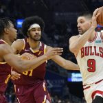 
              Chicago Bulls' Zach LaVine (8) drives past Cleveland Cavaliers' Isaac Okoro (35) and Jarrett Allen (31) in the first half of an NBA basketball game, Wednesday, Dec. 8, 2021, in Cleveland. (AP Photo/Tony Dejak)
            
