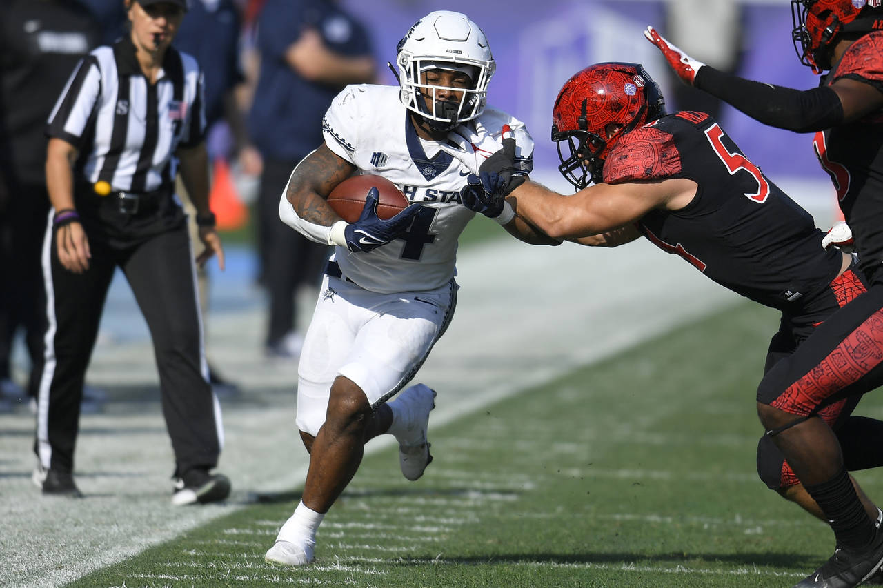 Utah State running back Calvin Tyler Jr. (4) is pushed out of bounds by San Diego State linebacker ...