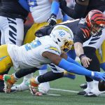 
              Los Angeles Chargers' Uchenna Nwosu (42) and Cincinnati Bengals quarterback Joe Burrow (9) dive for a fumble by Burrow during the first half of an NFL football game, Sunday, Dec. 5, 2021, in Cincinnati. Nwosu recovered the fumble. (AP Photo/Michael Conroy)
            