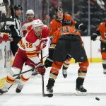 
              Calgary Flames' Trevor Lewis, left, moves the puck past Anaheim Ducks' Hampus Lindholm during the first period of an NHL hockey game Friday, Dec. 3, 2021, in Anaheim, Calif. (AP Photo/Jae C. Hong)
            