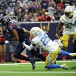 
              Houston Texans wide receiver Nico Collins (12) catches a pass for a touchdown as Los Angeles Chargers' Chris Harris Jr. (25) and Nasir Adderley (24) defend during the second half of an NFL football game Sunday, Dec. 26, 2021, in Houston. (AP Photo/Justin Rex)
            