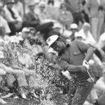 
              FILE - Lee Elder hits the ball from a sand trap on the 18th hole at the Augusta National Golf Club course in Augusta, Ga., on April 10, 1975. Elder is the first black golfer to play in the Masters tournament. Hank Aaron made history with one swing of his bat. A year later and on the other side of Georgia, Elder made history with one swing of his driver. Their deaths in 2021 were mourned beyond the sports world and were reminders of the hate, hardships and obstacles they endured with dignity on their way to breaking records and barriers. (AP Photo, File)
            