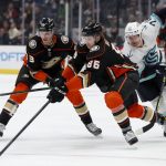 Anaheim Ducks defenseman Simon Benoit, center, vies for he puck with right wing Buddy Robinson, left, in front of Seattle Kraken right wing Joonas Donskoi, right, during the first period of an NHL hockey game in Anaheim, Calif., Wednesday, Dec. 15, 2021. (AP Photo/Alex Gallardo)