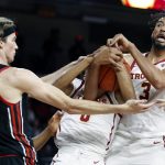 
              Southern California forward Isaiah Mobley, right, and center Lahat Thioune, center, vie for the ball against Utah center Branden Carlson, left, during the first half of an NCAA college basketball game in Los Angeles, Wednesday, Dec. 1, 2021. (AP Photo/Alex Gallardo)
            