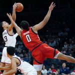 
              Texas Tech forward Kevin Obanor (0) and Gonzaga guard Andrew Nembhard (3) battle for a loose ball as Gonzaga forward Colby Brooks, front left, looks on during the second half of an NCAA college basketball game at the Jerry Colangelo Classic Saturday, Dec. 18, 2021, in Phoenix. Gonzaga won 69-55. (AP Photo/Ross D. Franklin)
            
