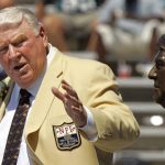 
              FILE - Former Oakland Raiders coach John Madden gestures toward a bust of himself during his enshrinement into the Pro Football Hall of Fame in Canton, Ohio, Aug. 5, 2006. John Madden, the Hall of Fame coach turned broadcaster whose exuberant calls combined with simple explanations provided a weekly soundtrack to NFL games for three decades, died Tuesday, Dec. 28, 2021, the NFL said. He was 85. (AP Photo/Mark Duncan, File)
            