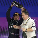 
              Mercedes driver Lewis Hamilton of Britain celebrate with a team member after winning the Formula One Saudi Arabian Grand Prix in Jiddah, Sunday, Dec. 5, 2021. (AP Photo/Hassan Ammar)
            