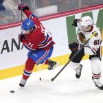 
              Chicago Blackhawks' Riley Stillman, right, loses his stick as he battles for the puck against Montreal Canadiens' Jake Evans during first-period NHL hockey game action in Montreal, Thursday, Dec. 9, 2021. (Paul Chiasson/The Canadian Press via AP)
            