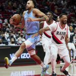 
              Memphis Grizzlies forward Kyle Anderson, left, drives past Portland Trail Blazers forward Norman Powell during the first half of an NBA basketball game in Portland, Ore., Wednesday, Dec. 15, 2021. (AP Photo/Craig Mitchelldyer)
            