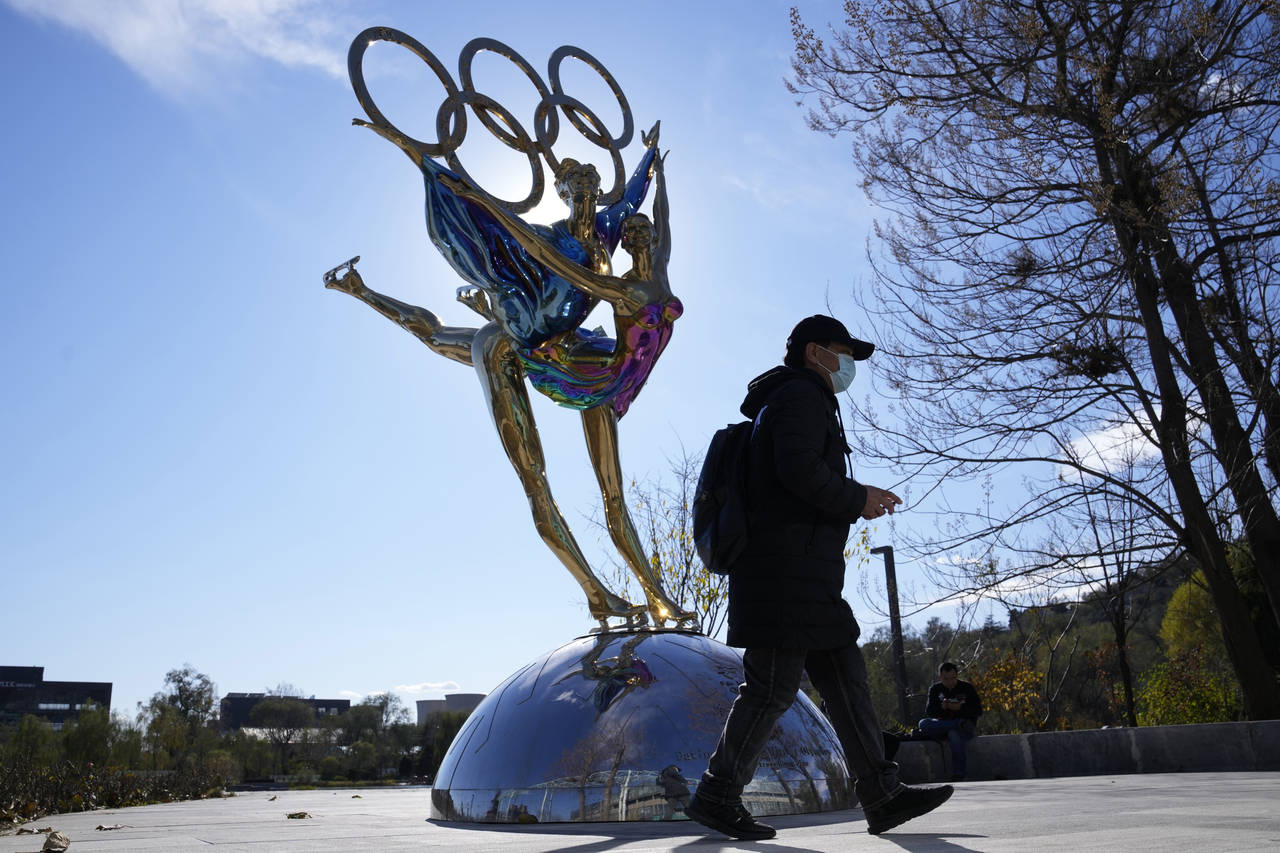 A visitor to the Shougang Park walks past the a sculpture for the Beijing Winter Olympics in Beijin...